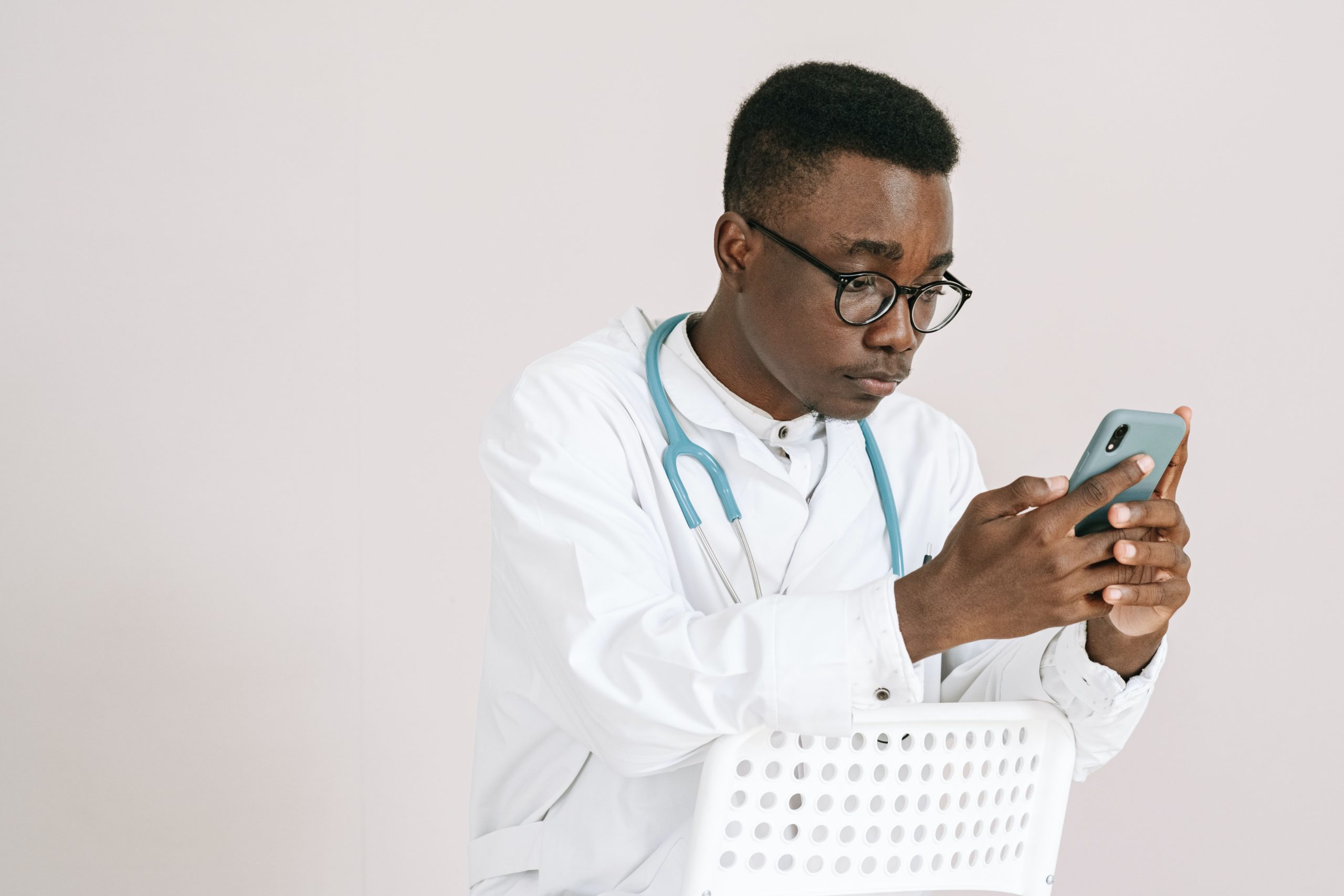 Titelbild: Arzt schaut auf seinem Handy ins DiGA Verzeichnis und möchte die richtige DiGA für seine Patienten finden