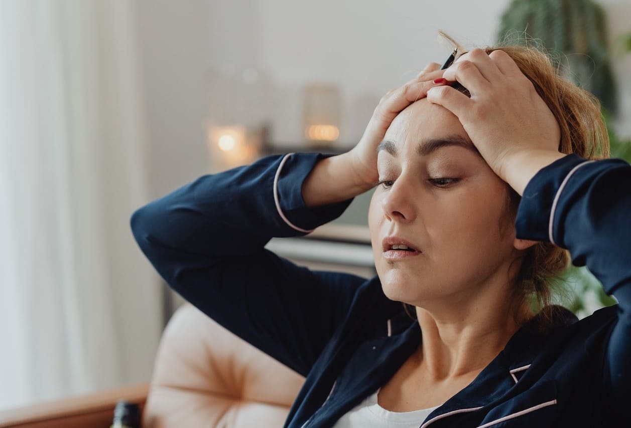 Titelbild: Burnout-Symptome bei Frau in Form von Kopfschmerzen