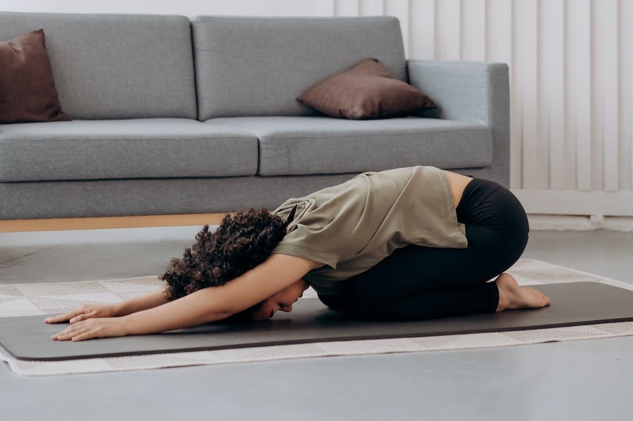 Titelbild: Frau auf Yogamatte will Beckenboden entspannen