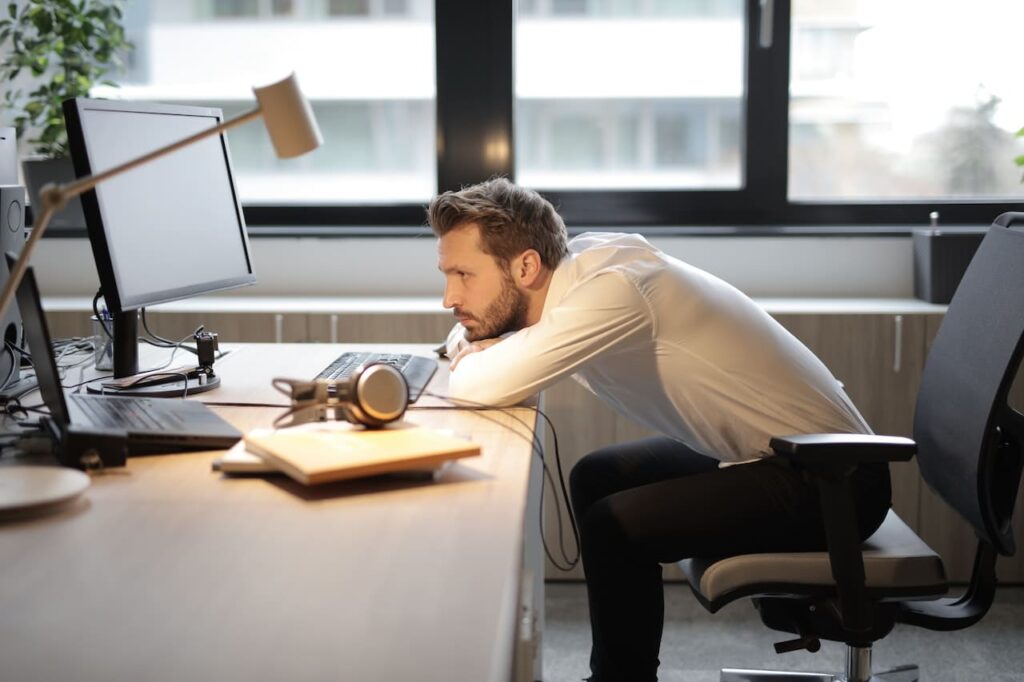 Titelbild: Erschöpfung als Burnout-Symptom bei Mann am Schreibtisch