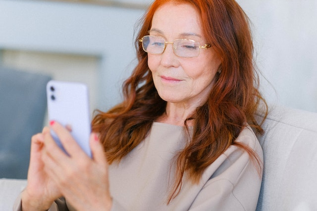 Patientenbeteiligung: Frau nutzt Handy um an User Research teilzunehmen