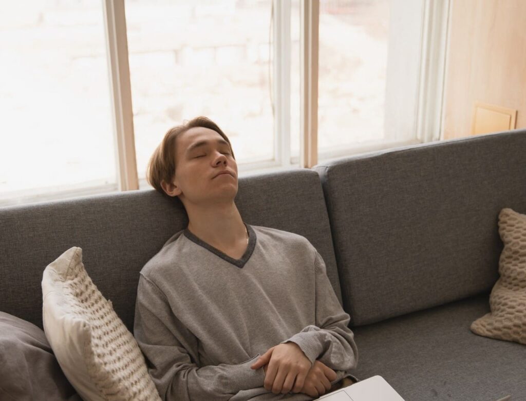 Titelbild: Junger Mann auf heimischem Sofa fühlt 